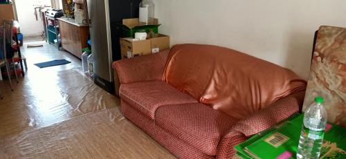 a red couch in a living room with a bottle of water at Low Budget SingleBed Bedroom in Kuala Lumpur