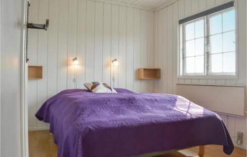 a purple bed in a white room with a window at Awesome Home In Ringkbing With 3 Bedrooms, Sauna And Wifi in Søndervig