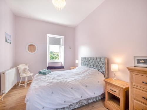 Un dormitorio con una gran cama blanca y una ventana en Lincumtoy, en Ballantrae
