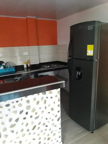 a kitchen with a black refrigerator and a stove at Paraíso Escondido in San Rafael