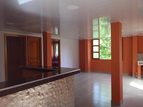 a kitchen with orange and white walls and a window at Paraíso Escondido in San Rafael