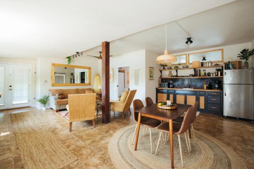 una cucina e un soggiorno con tavolo e sedie di The Ohia at The Koi House a Kailua-Kona