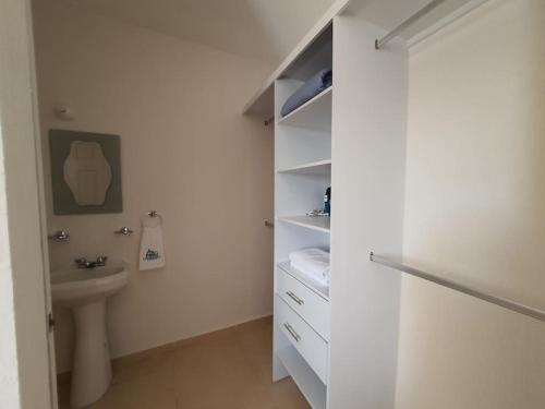 a white bathroom with a toilet and a sink at Casa de 3 habitaciones TODAS con baño propio, 3 y medio baños en toal, alberca, cupo hasta 12 personas in Playa del Carmen