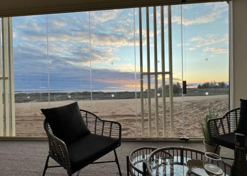 a room with a view of the beach through a window at Marina Sunset Resort A2 in Kalajoki