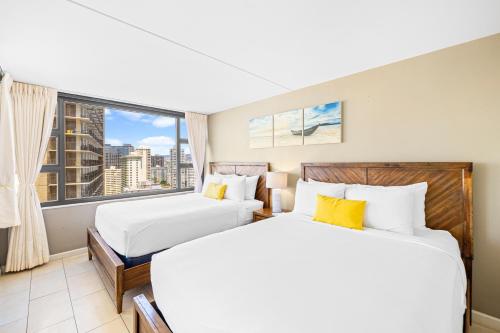 ホノルルにあるGreat Ocean View Condo, Near Beach with Free Parking!の大きな窓付きのホテルルームのベッド2台