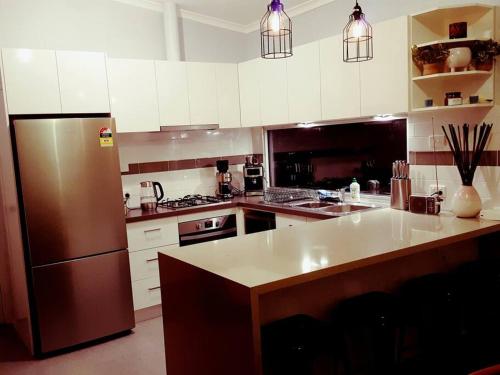 una cocina con nevera y electrodomésticos de acero inoxidable en Wild Brumby- A cozy home away from home, en Corryong