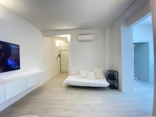 een witte kamer met een bed en een flatscreen-tv bij Apartment Belfiore in Milaan