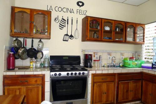 a kitchen with wooden cabinets and a stove top oven at Matagalpa Tours Guest House in Matagalpa