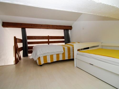 1 dormitorio con 2 camas con sábanas blancas y amarillas en Appartement Saint-Cyprien, 2 pièces, 4 personnes - FR-1-309-313, en Saint-Cyprien