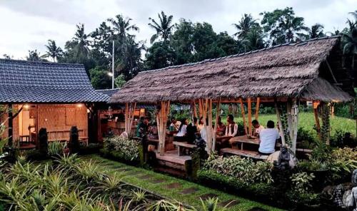 a group of people sitting in a hut at BaliFarmhouse in Banjarangkan