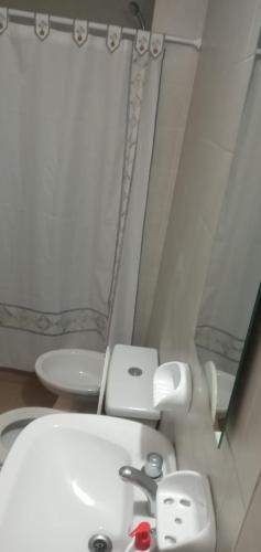 y baño con lavabo blanco y espejo. en Departamento céntrico 2 en Mendoza