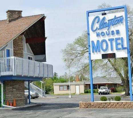 - un panneau indiquant une maison de vacances dans un parking dans l'établissement Clayton House Motel, à Loves Park