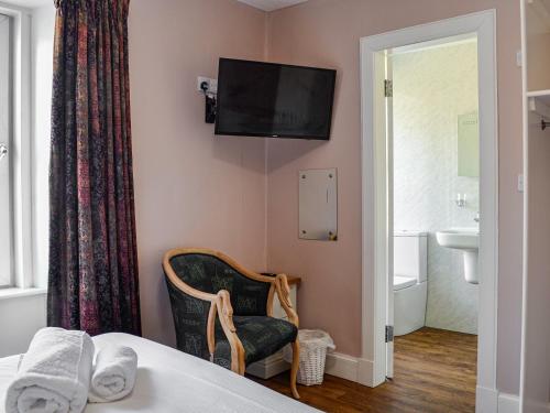 a hotel room with a bed and a television on the wall at Montys in Castle Douglas