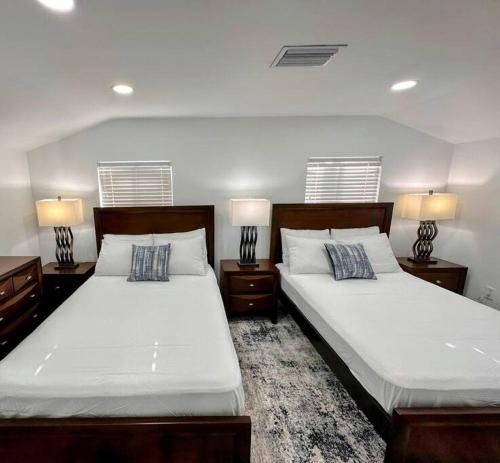 2 Betten in einem Schlafzimmer mit 2 Lampen an Tischen in der Unterkunft Entire 3/1 house near Wynwood! in Miami