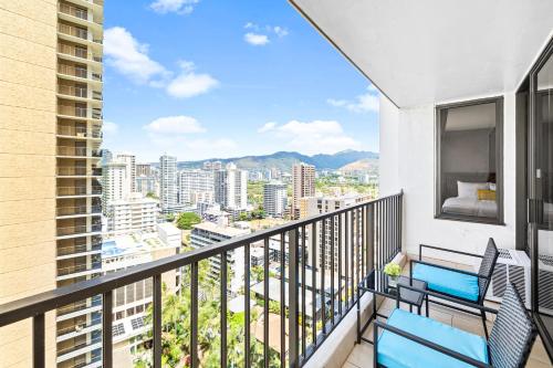 a balcony with two chairs and a view of the city at Great Ocean View Condo, Near Beach with Free Parking! in Honolulu