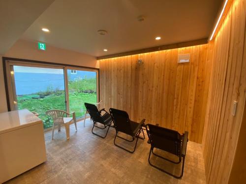 a room with chairs and a table and a window at The Toya in Lake Toya