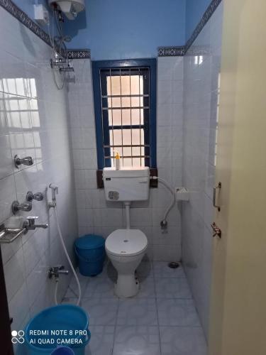 a bathroom with a white toilet and a window at Maity lodge in Gangtok