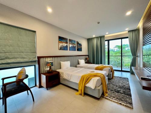 1 dormitorio con 2 camas, escritorio y ventana en West Phu Quoc 3BR beach villa private swimming pool en Phu Quoc