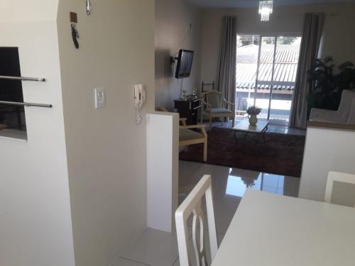 cocina y sala de estar con paredes blancas y puerta corredera en UNIJUI, en Ijuí