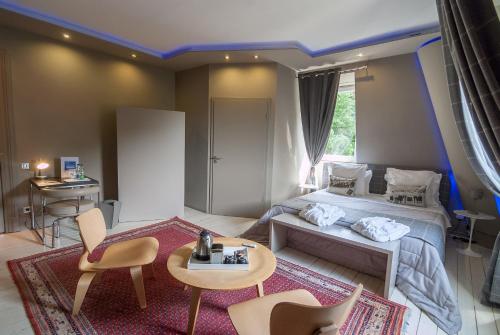 a room with a bed, table, chairs and a rug at Peonia at Home - Maison d'hôtes d'exception in Mulhouse