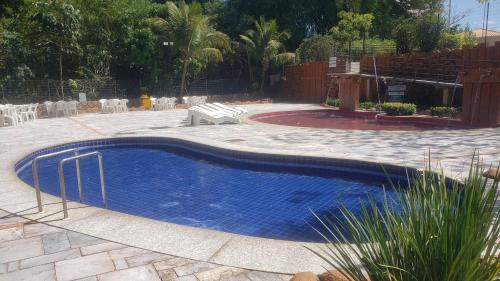 a blue swimming pool in a yard with a patio at Flat 902 Golden Dolphin Express in Caldas Novas
