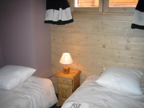 a bedroom with two beds and a lamp on a night stand at Charmant appartement avec WiFi et parking privé aux Gets - FR-1-671-79 in Les Gets