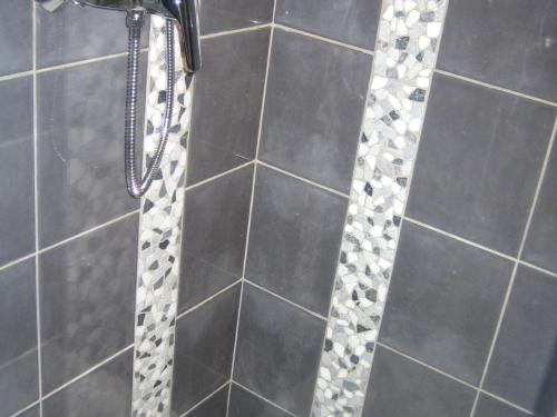 a shower with black and white tile and a shower constructor at Charmant appartement avec WiFi et parking privé aux Gets - FR-1-671-79 in Les Gets