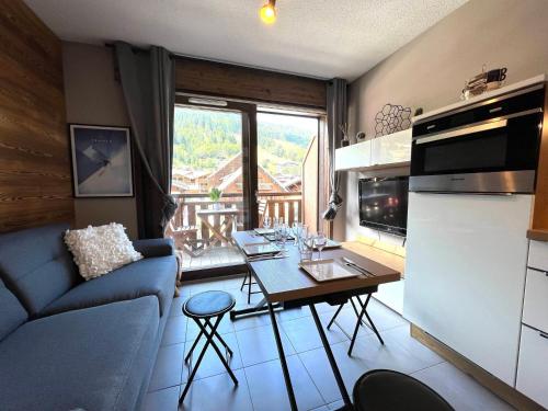 une cuisine et un salon avec une table et un canapé dans l'établissement Studio au Centre des Gets, Proche Remontées, Confort Moderne - 4 Couchages - FR-1-623-194, aux Gets