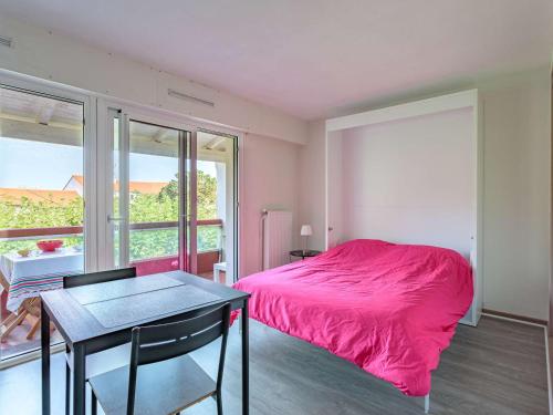 - une chambre avec un lit rose et une table dans l'établissement Studio lumineux avec balcon à 300m des plages d'Anglet - FR-1-3-596, à Anglet