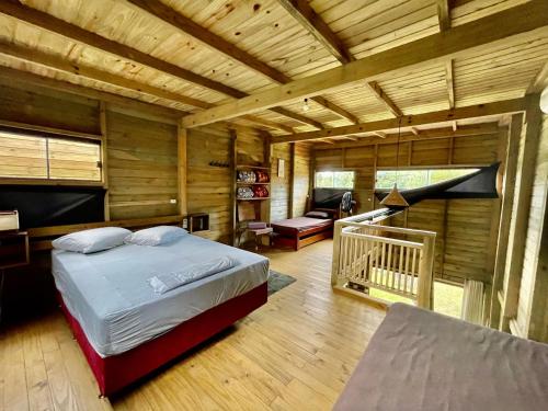 um quarto com uma cama num chalé de madeira em Rosa Lodge Lofts em Praia do Rosa