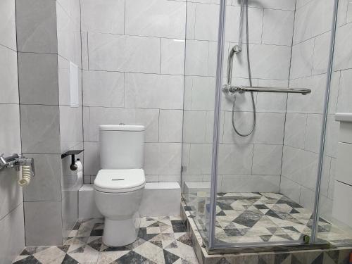 La salle de bains est pourvue de toilettes et d'une douche en verre. dans l'établissement Толе Би 57 - ТРЦ Хан Шатыр, à Astana
