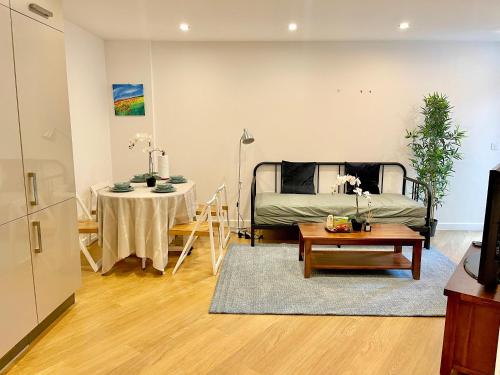 a living room with a bed and a table at Modern Patio Flat close to Sation & Canary Wharf in London