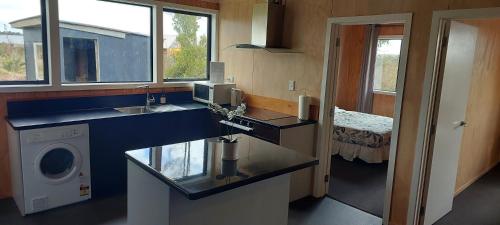 a kitchen with a sink and a washing machine at Tongariro Estate in National Park
