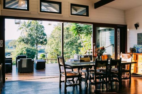 a dining room with a table and chairs and a large window at BELLINGEN CONVERTED CHURCH on the river (Pet Friendly) in Bellingen