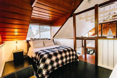a bedroom with a bed in a room with wooden ceilings at BELLINGEN CONVERTED CHURCH on the river (Pet Friendly) in Bellingen