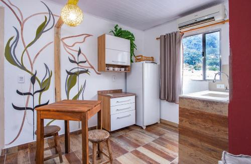 a kitchen with a table and a refrigerator at Pousada Castelinho in São Sebastião