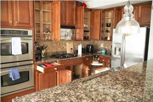 a kitchen with wooden cabinets and stainless steel appliances at Open Floor Plan, Spa Tub, Fully Stocked Kitchen, King Bed in Frederick