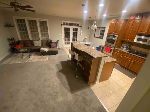 a kitchen with a counter top and a living room at Open Floor Plan, Spa Tub, Fully Stocked Kitchen, King Bed in Frederick