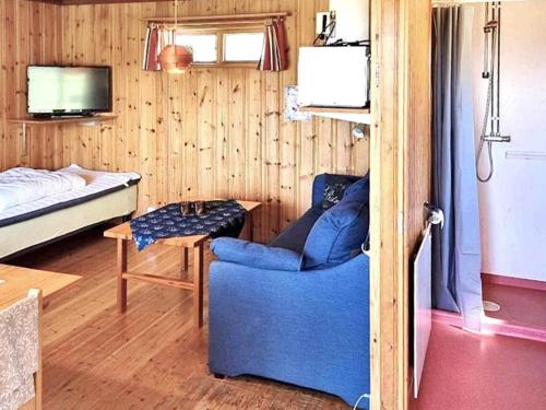 a living room with a blue chair and a bed at Holiday home RÄTTVIK in Rättvik