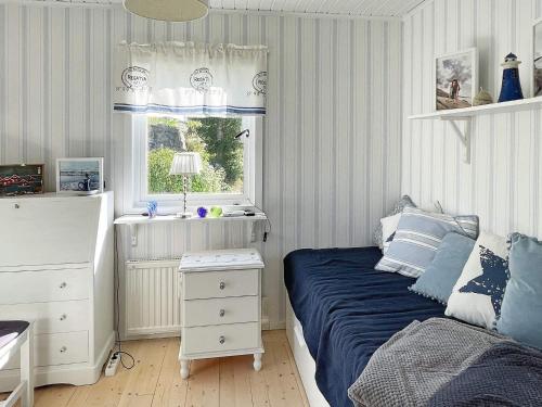 ein kleines Schlafzimmer mit einem Bett und einem Fenster in der Unterkunft Holiday home SKÄRHAMN in Skärhamn