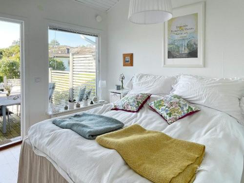 una cama blanca con almohadas en una habitación en Holiday home SKÄRHAMN, en Skärhamn