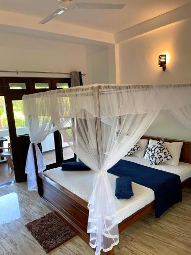a bedroom with a bed with a canopy at Shan Star Weligama in Weligama