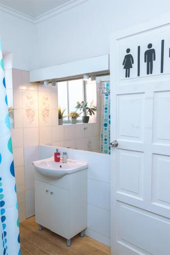a bathroom with a white door and a sink at Tagle Casa del Lado Santiago Providencia in Santiago