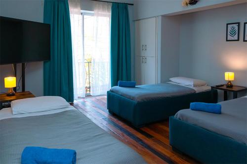 a hotel room with two beds and a couch at Tagle Casa del Lado Santiago Providencia in Santiago