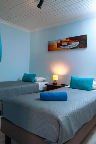two beds with blue pillows in a room at Tagle Casa del Lado Santiago Providencia in Santiago