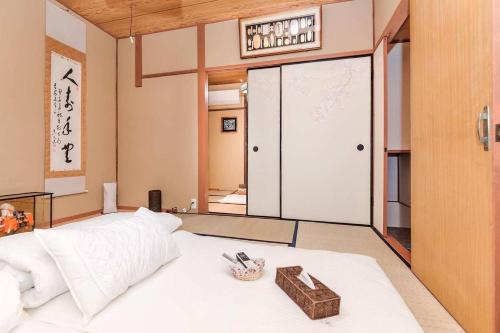a bedroom with a white bed with a basket on it at 喜楽-炎林苑 in Kyoto