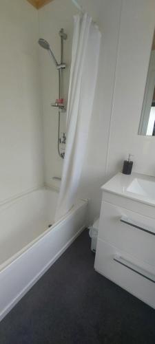 a white bathroom with a tub and a sink at Tongariro Estate in National Park
