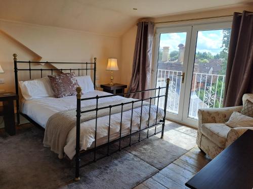 1 dormitorio con 1 cama, 1 silla y 1 ventana en Maidenhead House Serviced Accommodation in quiet residential area, free parking, 3 bedrooms, WiFi 1 Gbps, work desks, office chairs, TV 55" Roku, Company stays, couples and families welcome, sleeps 6 en Maidenhead