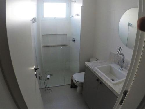 a bathroom with a shower and a toilet and a sink at PRAIA BRAVA 3 QUARTOS, CONDOMÍNIO COMPLETO in Itajaí