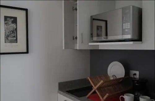 a kitchen with a microwave and a counter top at Q'entiHospedaje Lucrepata 1 in Cusco